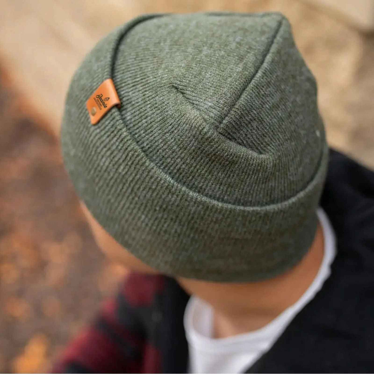 Green H-Stitch beanie with a brand logo worn by a person outdoors