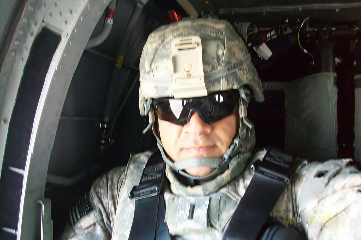 Person in military gear inside a helicopter